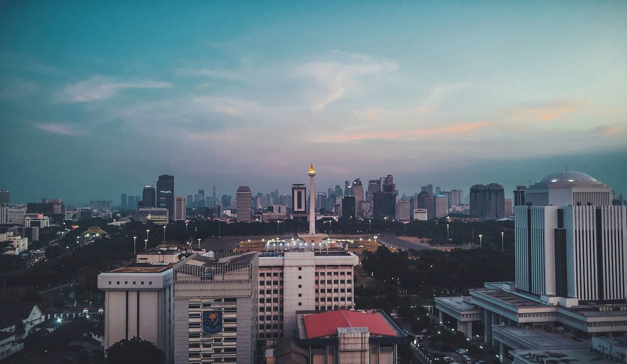 MODERN BUILDINGS IN CITY AGAINST SKY DURING SUNSET