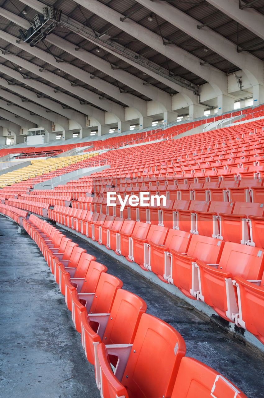 Empty orange seats at stadium,rows walkway of seat on a soccer stadium