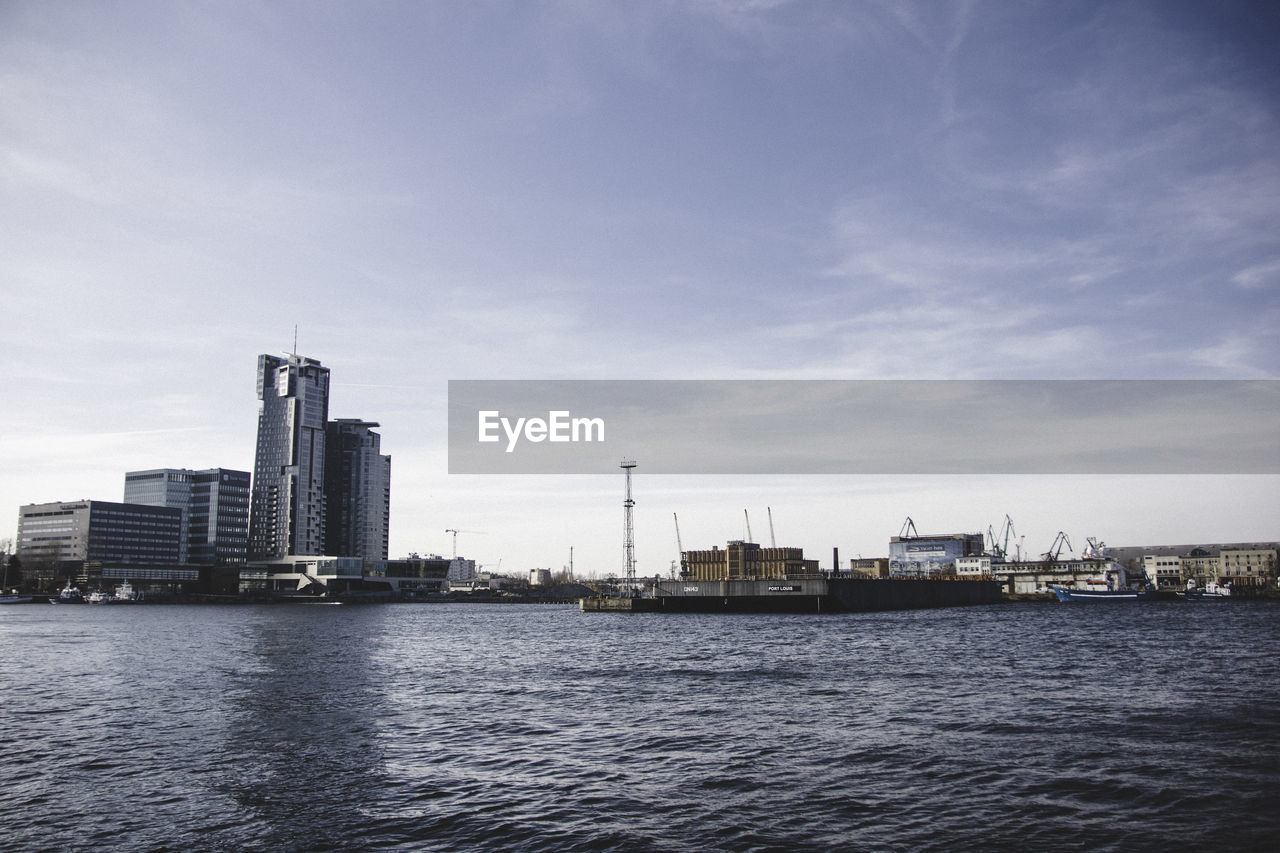 RIVER AND BUILDINGS AGAINST SKY IN CITY