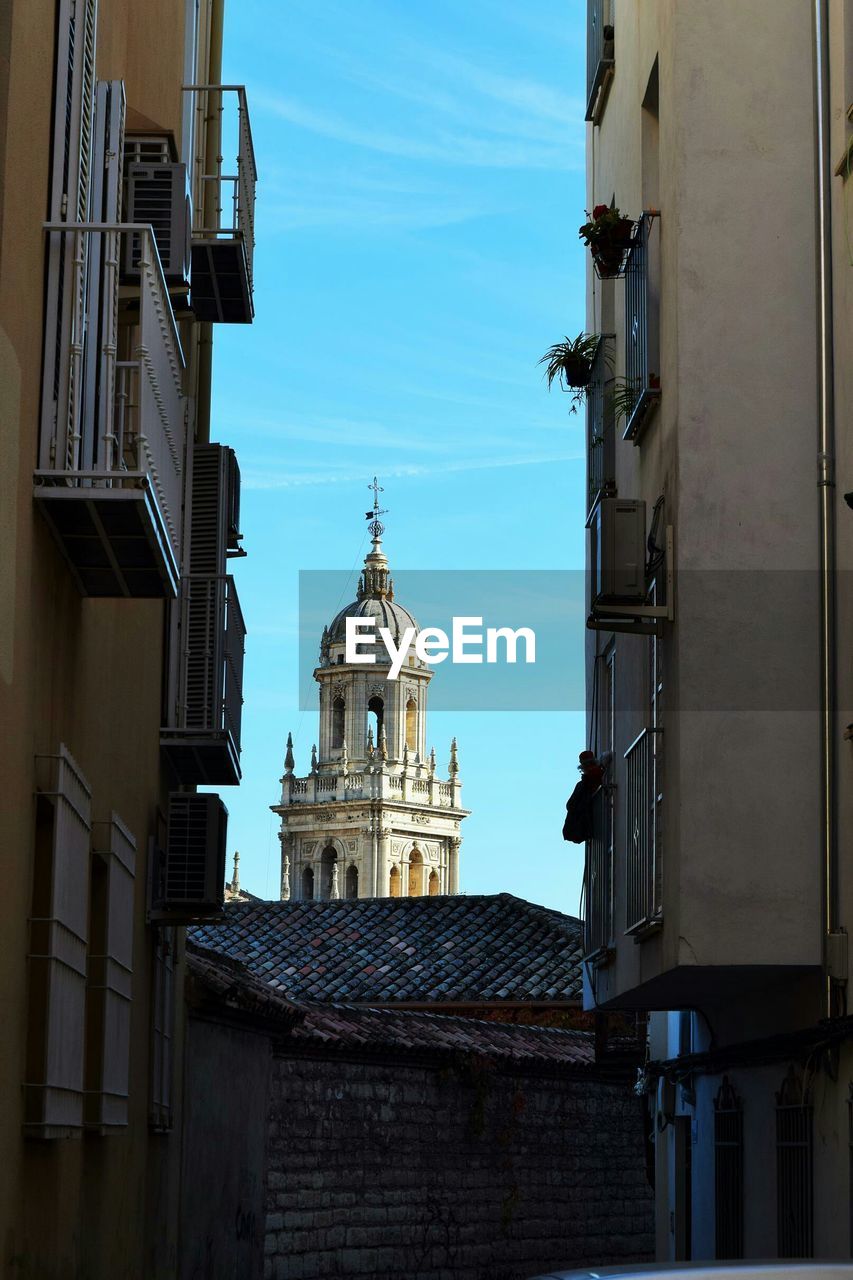 Church and residential buildings against sky