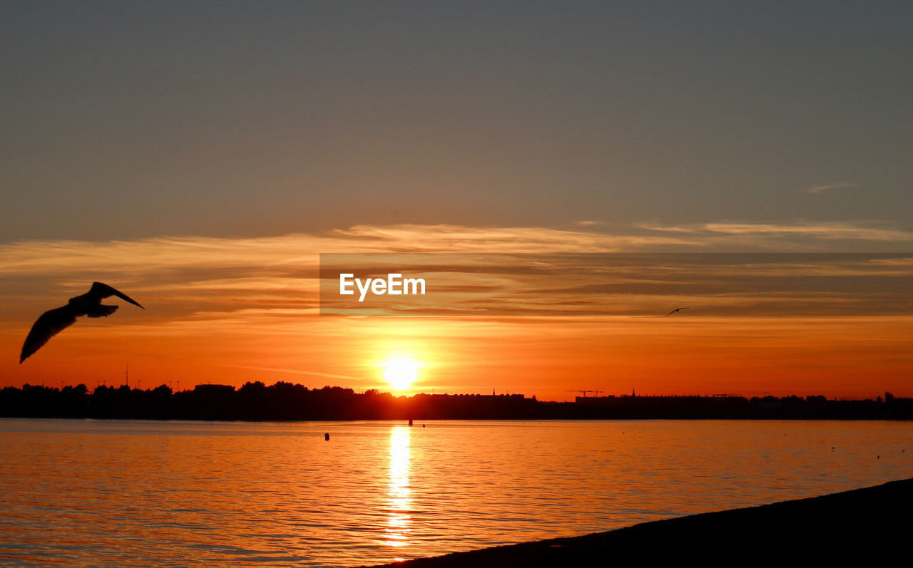 SCENIC VIEW OF LAKE AGAINST ORANGE SKY DURING SUNSET