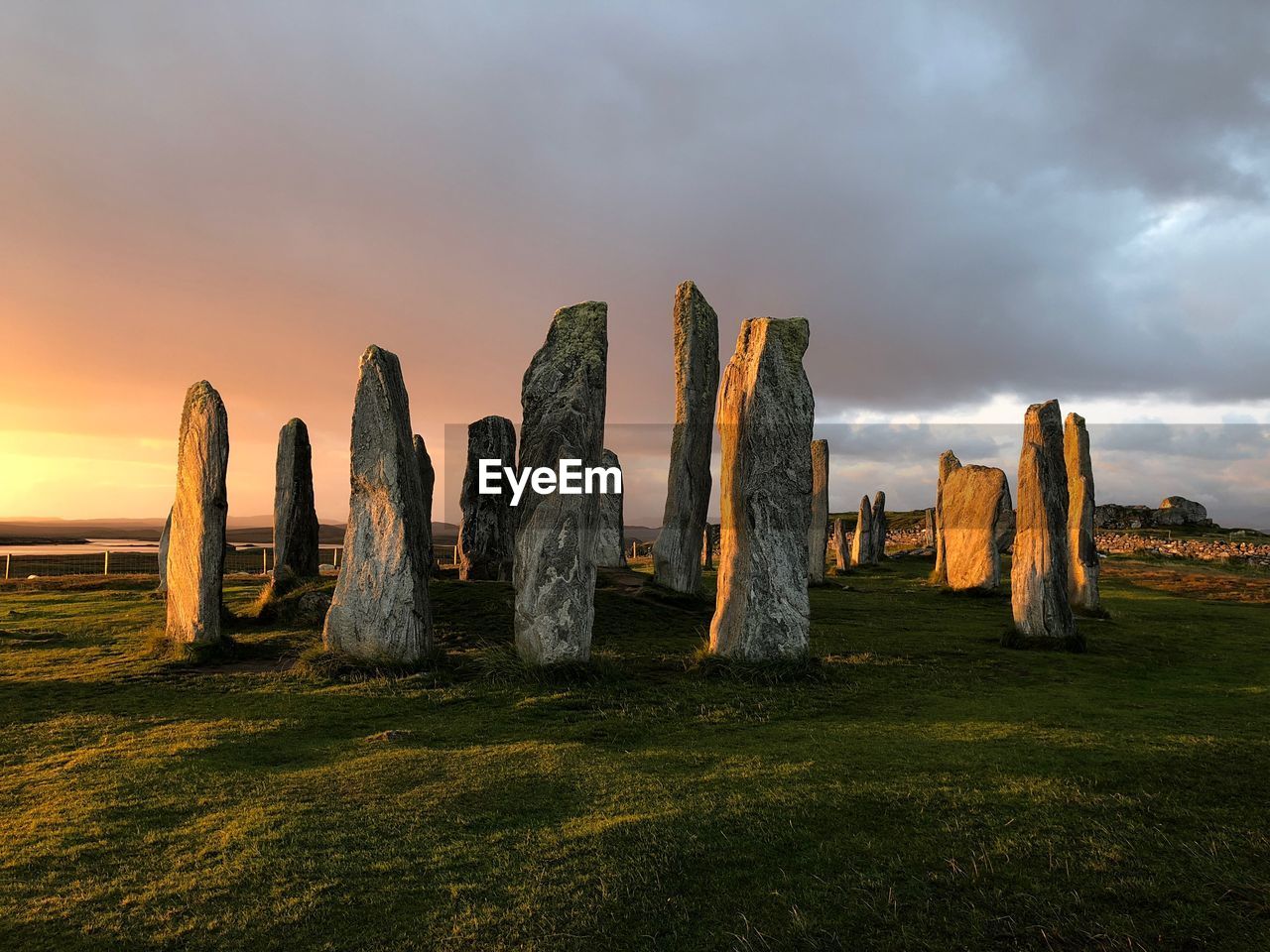 PANORAMIC VIEW OF ROCKS ON FIELD AGAINST SKY