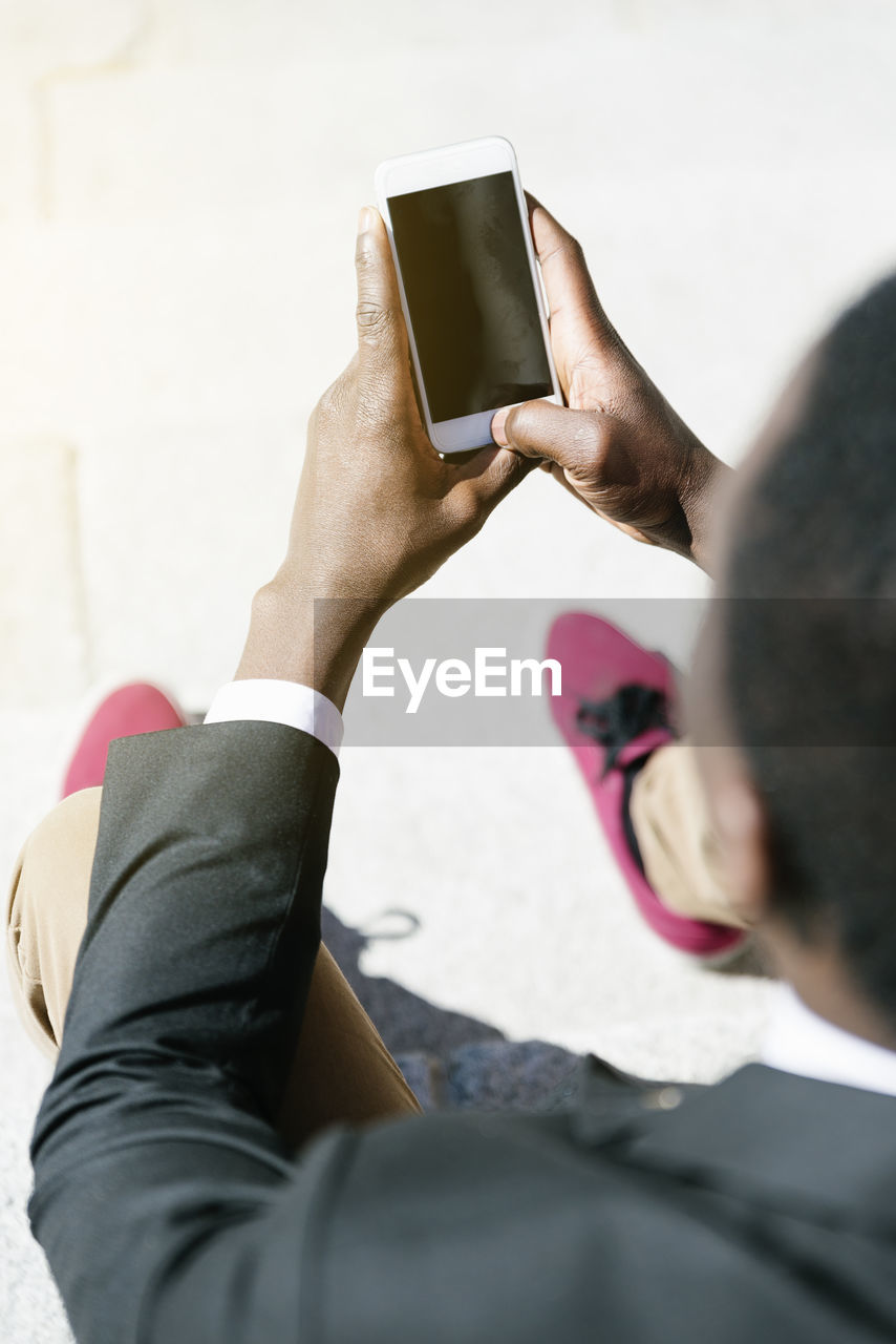 High angle view of man using smart phone while sitting in office