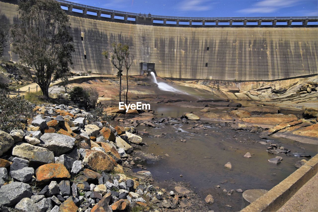 Rocks and tree against dam