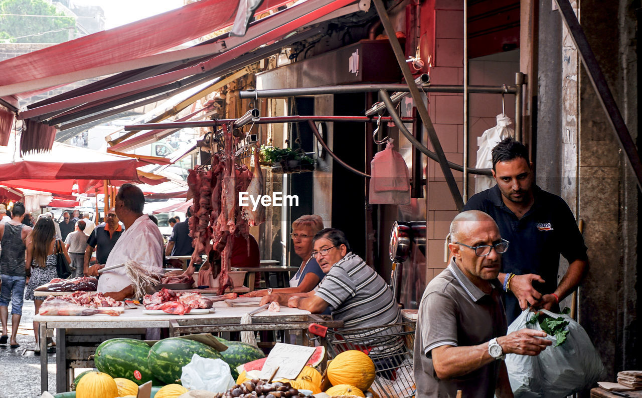 GROUP OF PEOPLE IN MARKET STALL