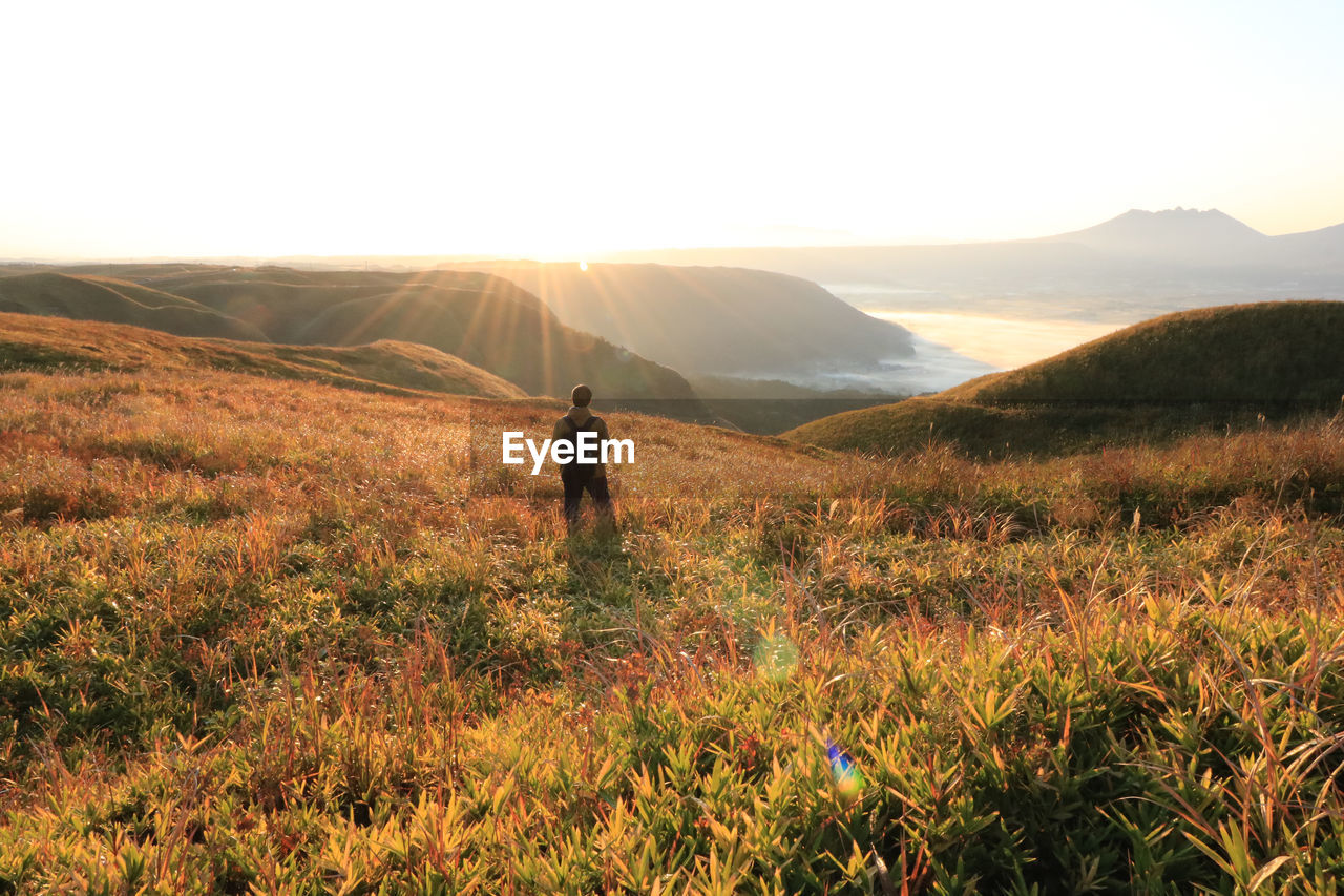 Man standing on landscape against clear sky