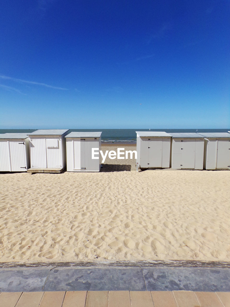 Scenic view of beach against clear blue sky