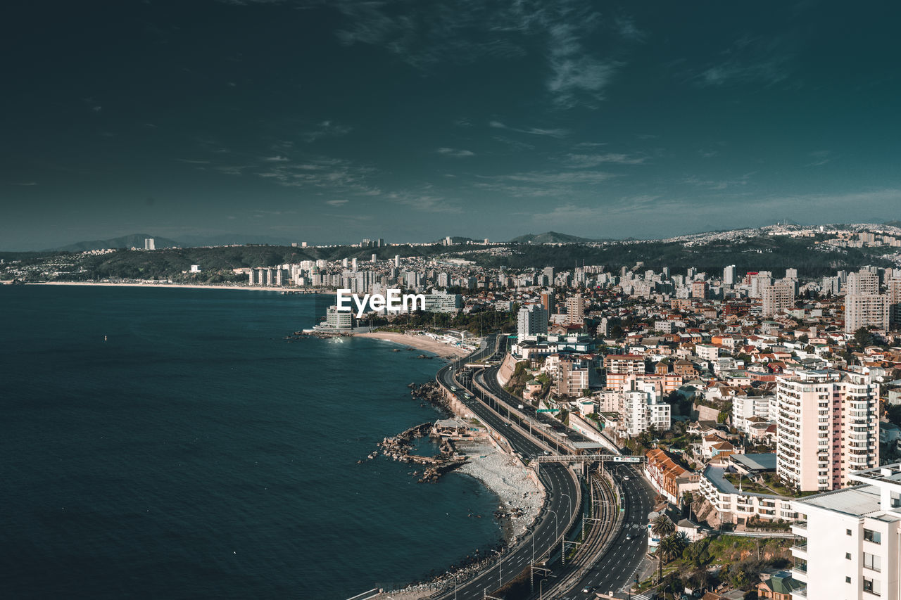 High angle view of buildings by sea against sky