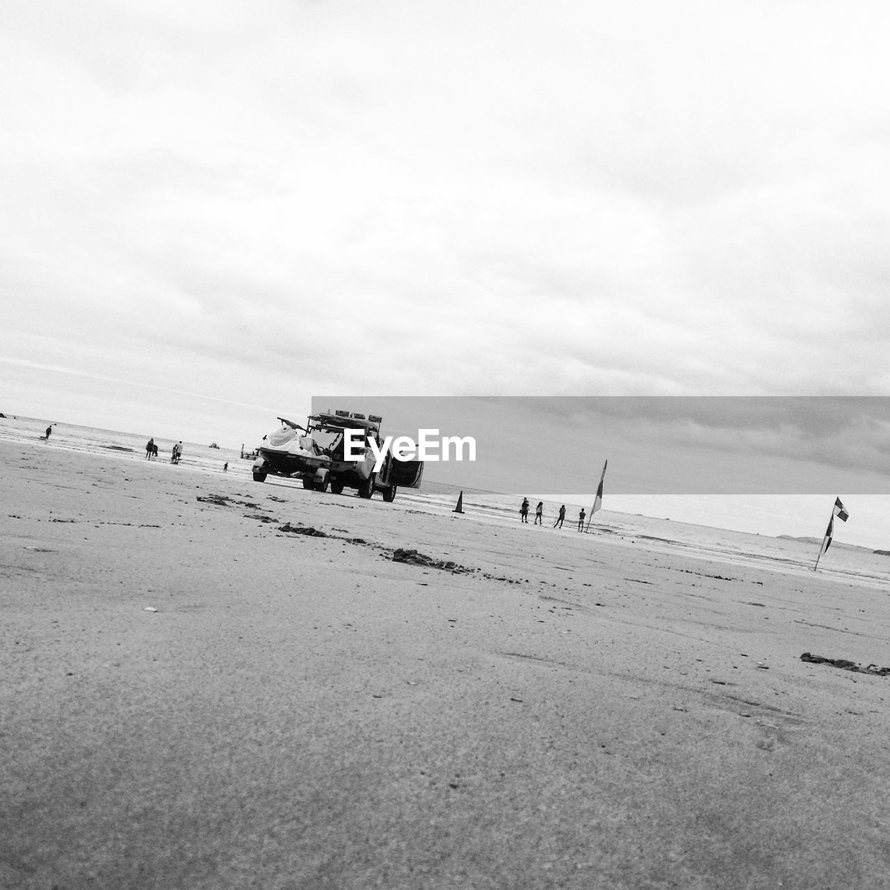 MAN CYCLING ON SAND AGAINST SKY