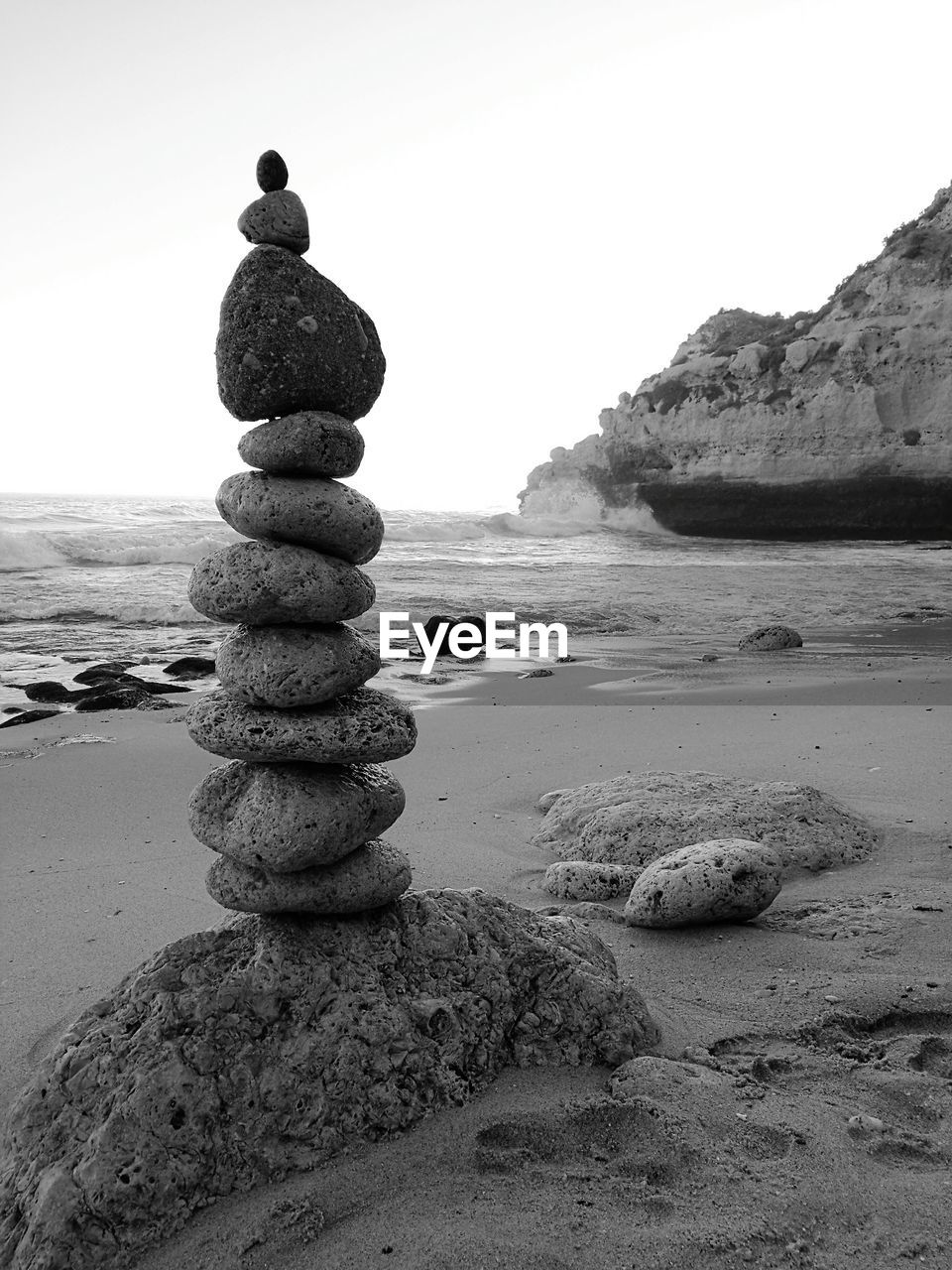 Stack of pebbles at beach against clear sky