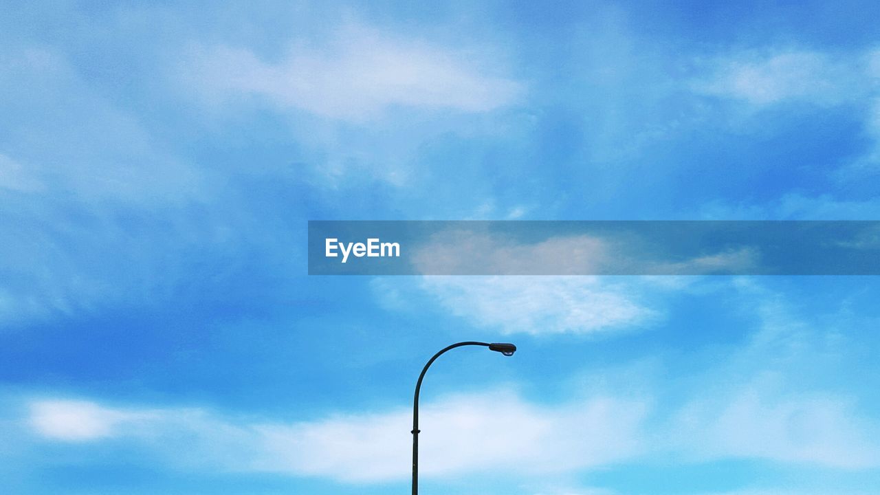 Low angle view of street light against cloudy sky