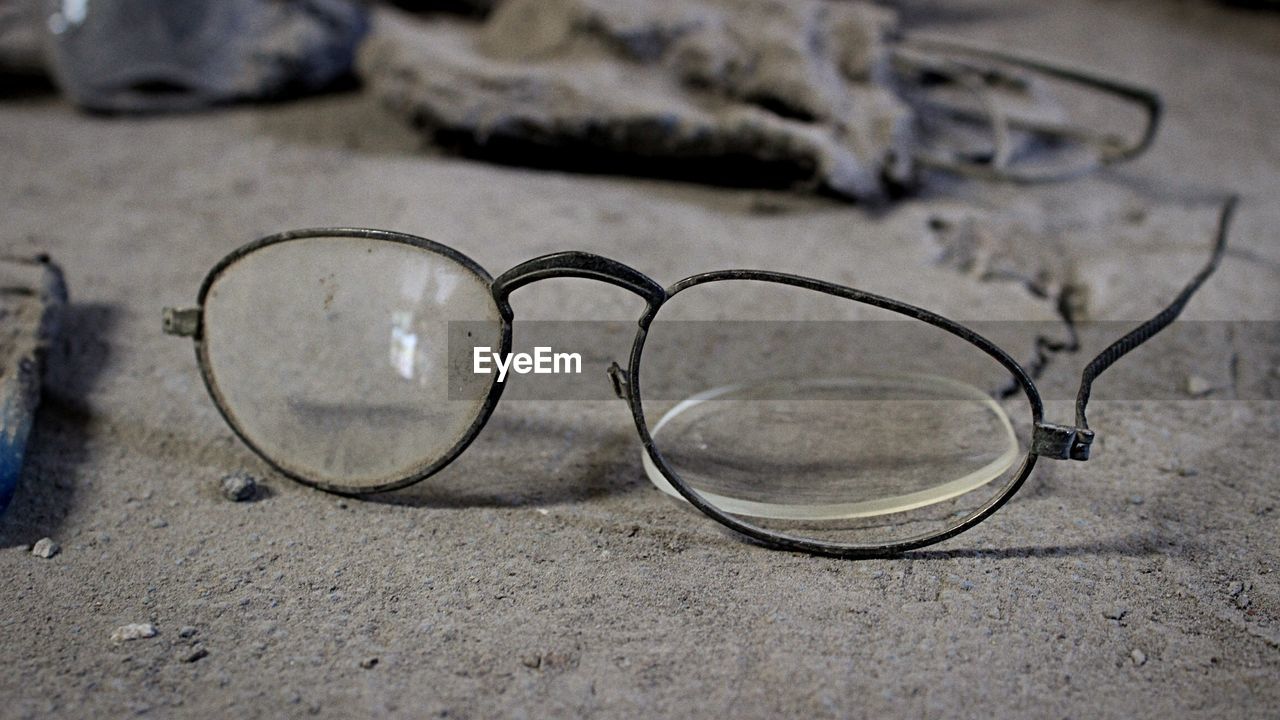 Broken eyeglasses on messy floor