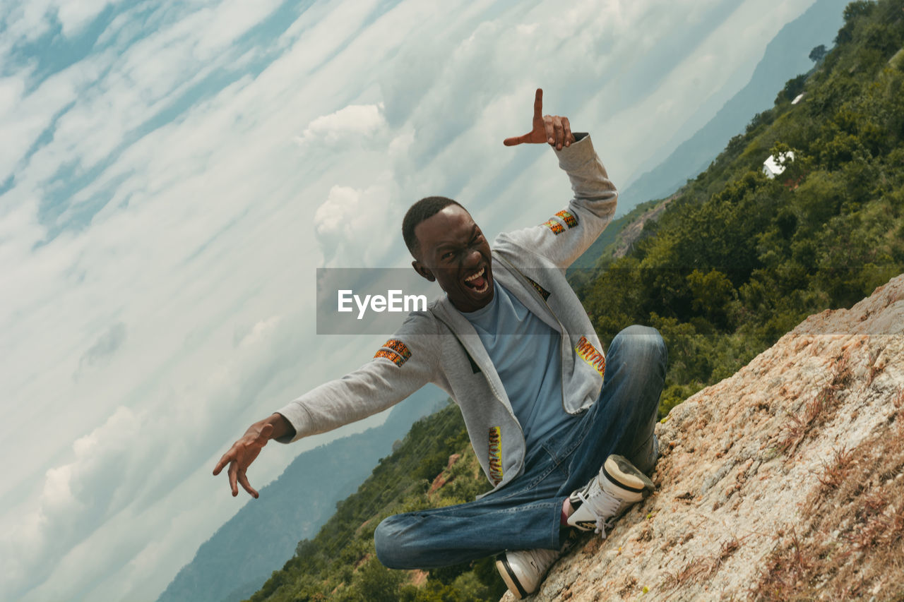 A man showing positive emotion on top of a hill
