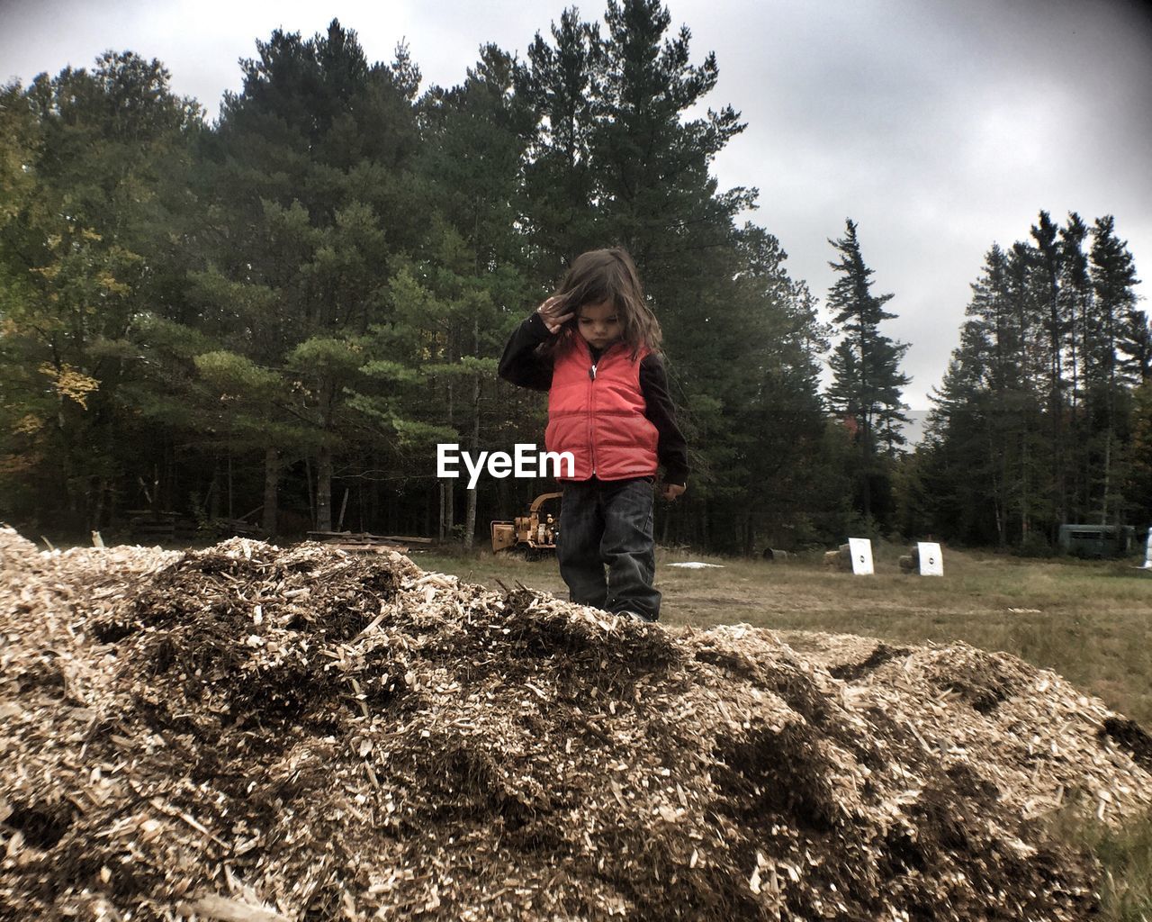 Girl walking on rock against field