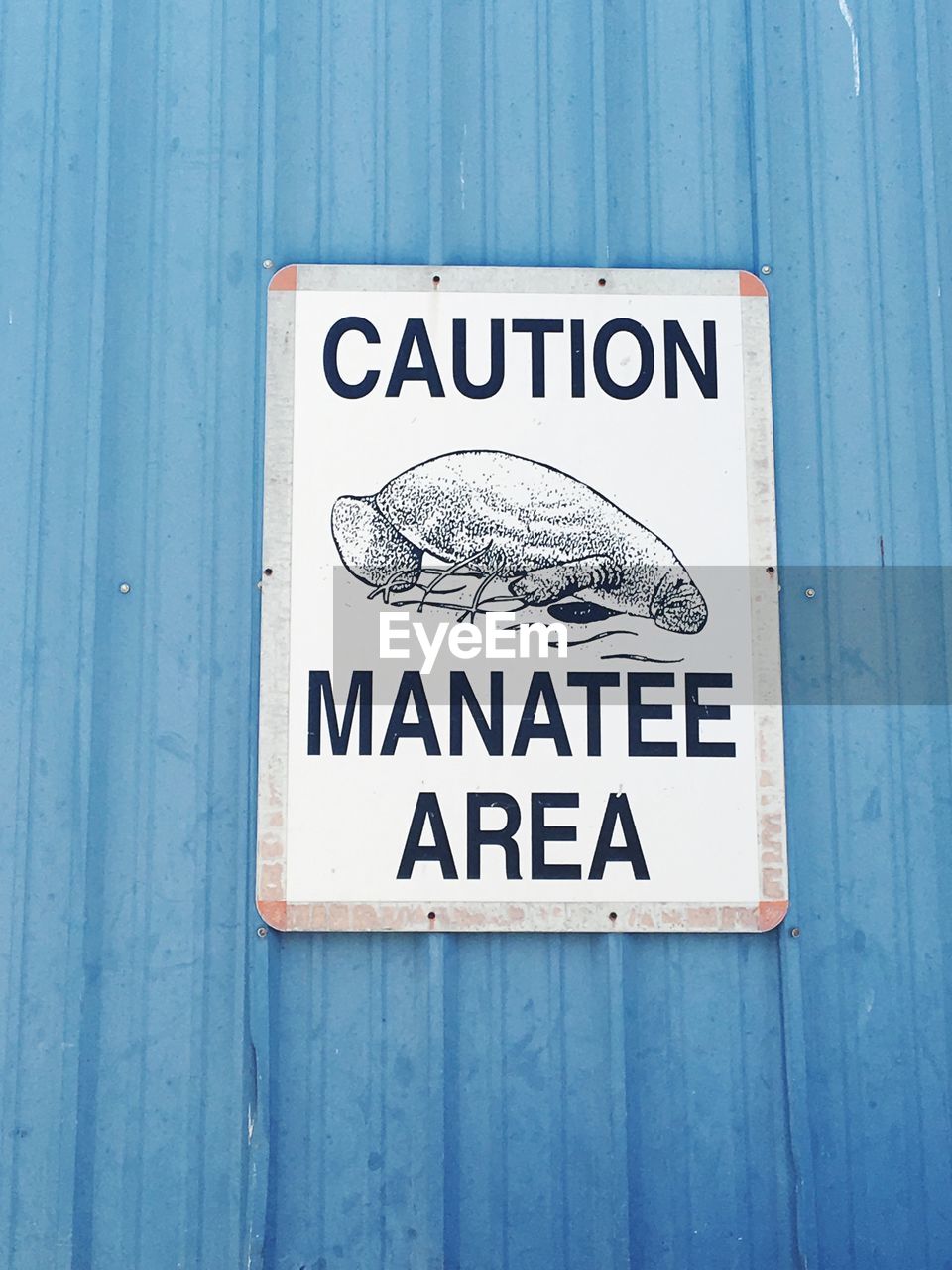 CLOSE-UP OF WARNING SIGN ON BLUE WOODEN DOOR