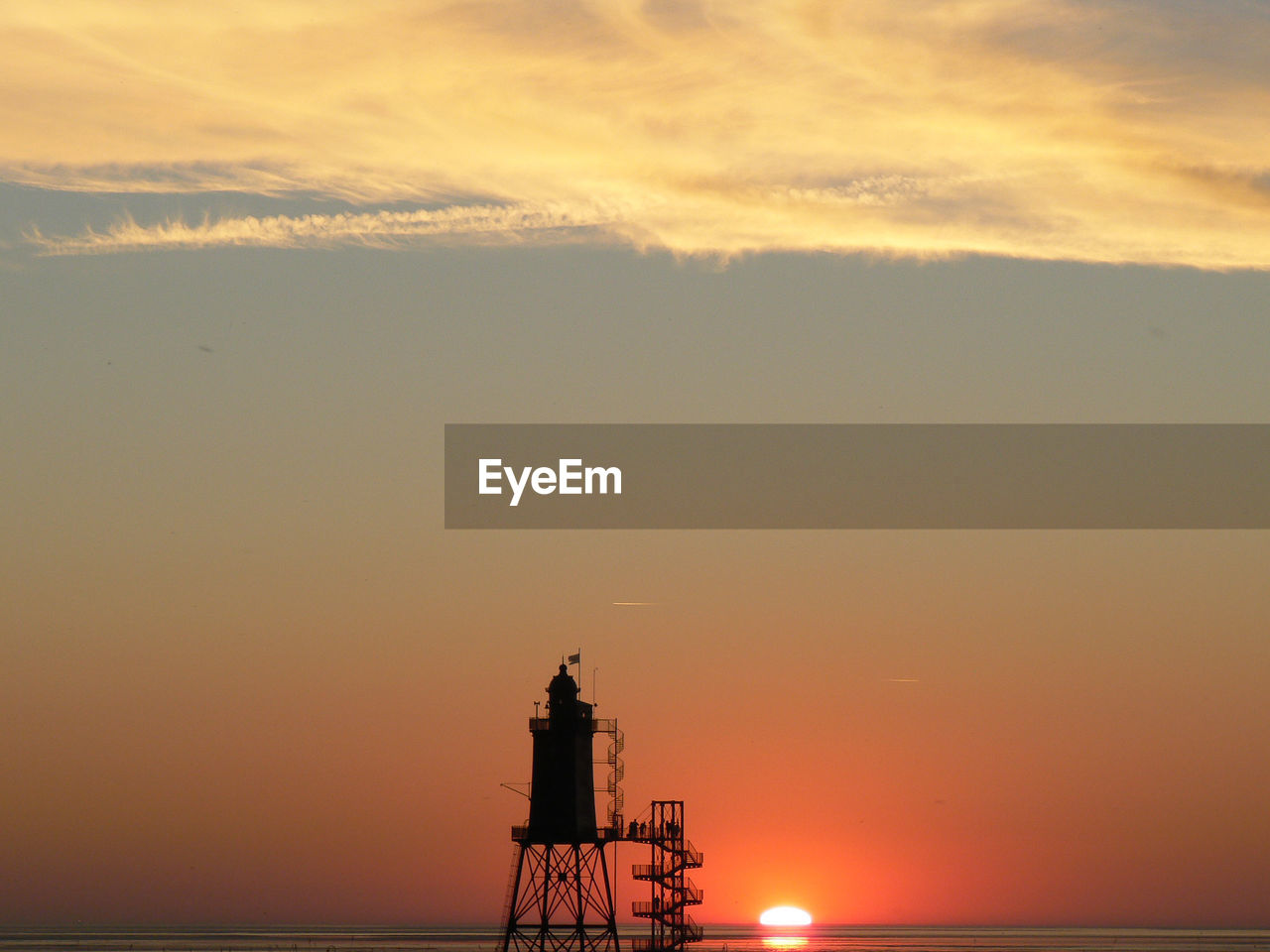 Silhouette lighthouse against sky during sunset