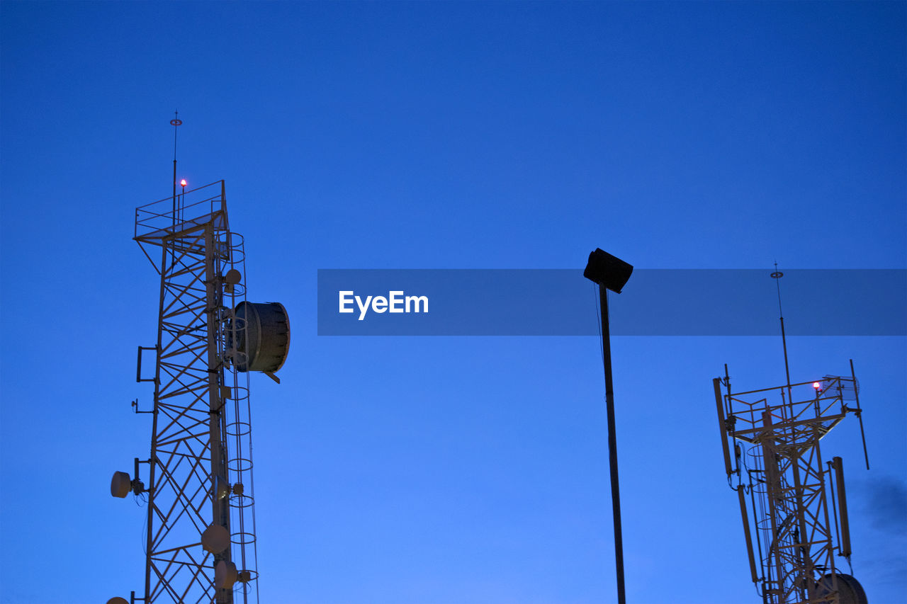 Low angle view of communications tower against sky at dusk