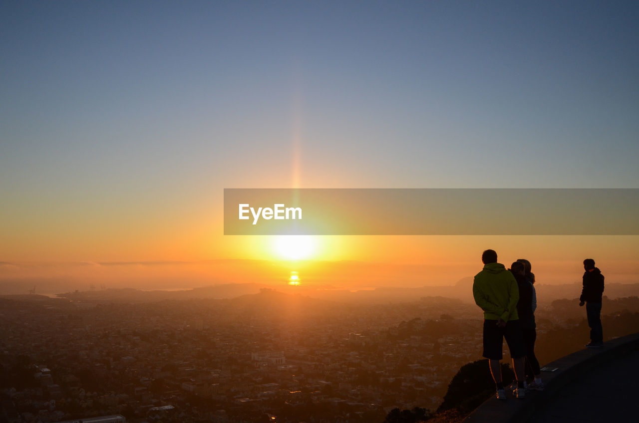 People looking at cityscape of san francisco at sunrise