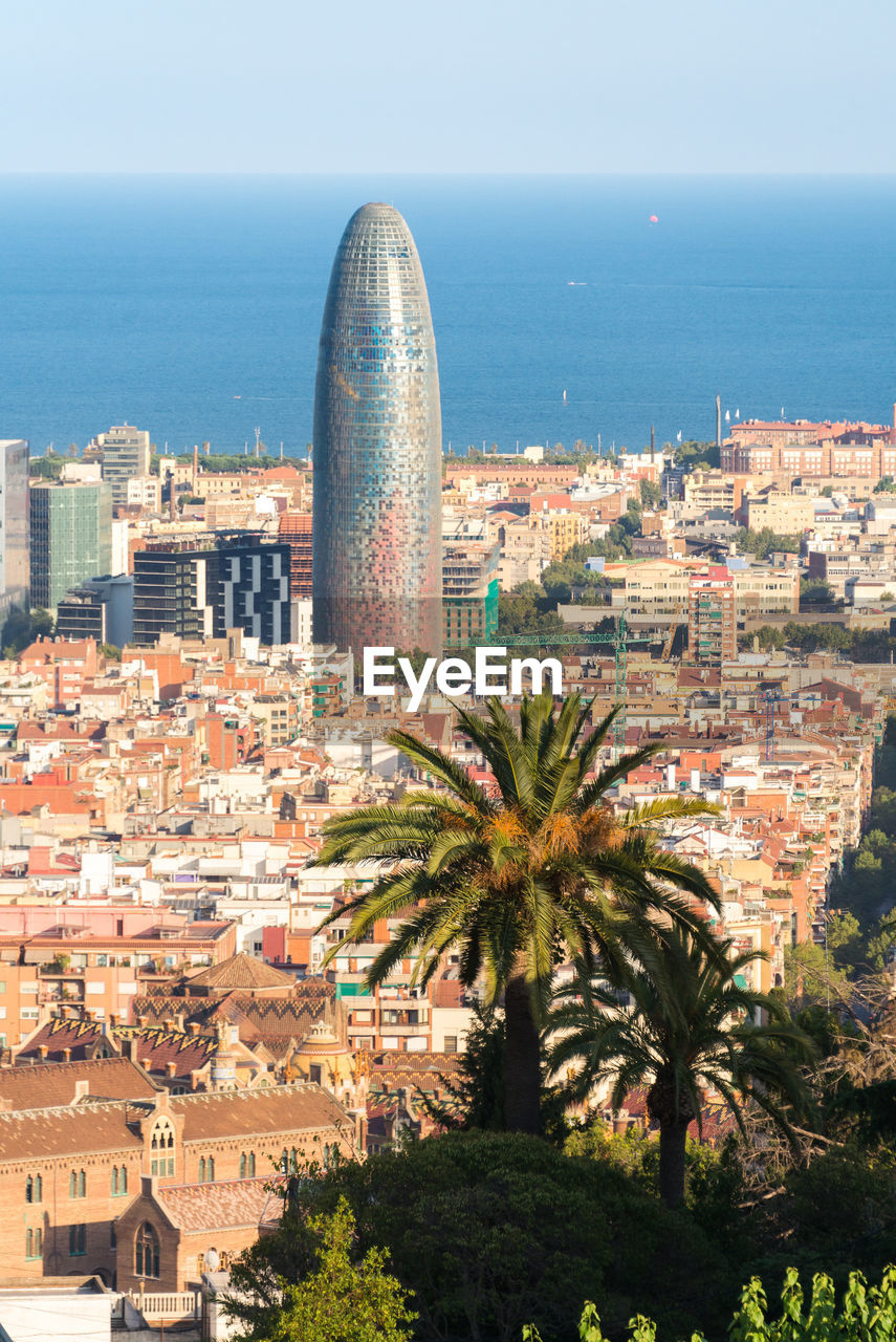 HIGH ANGLE VIEW OF BUILDINGS AGAINST SEA