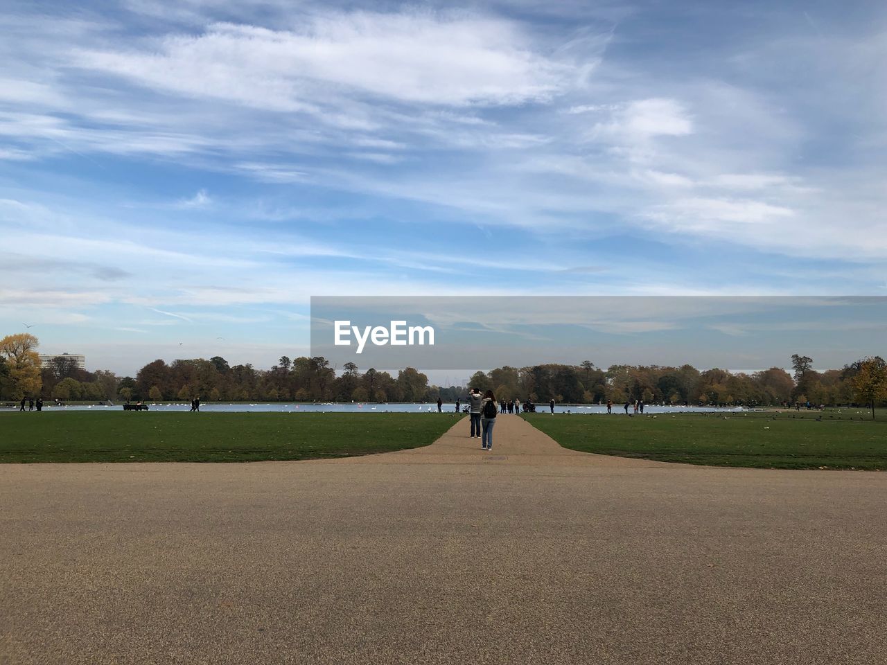 MAN WALKING ON FIELD AGAINST SKY