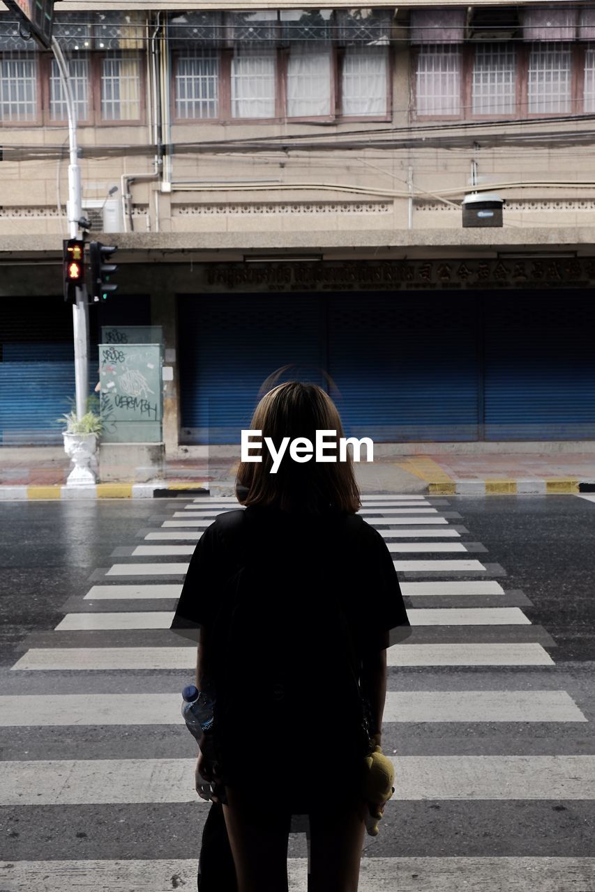 Rear view of woman crossing road