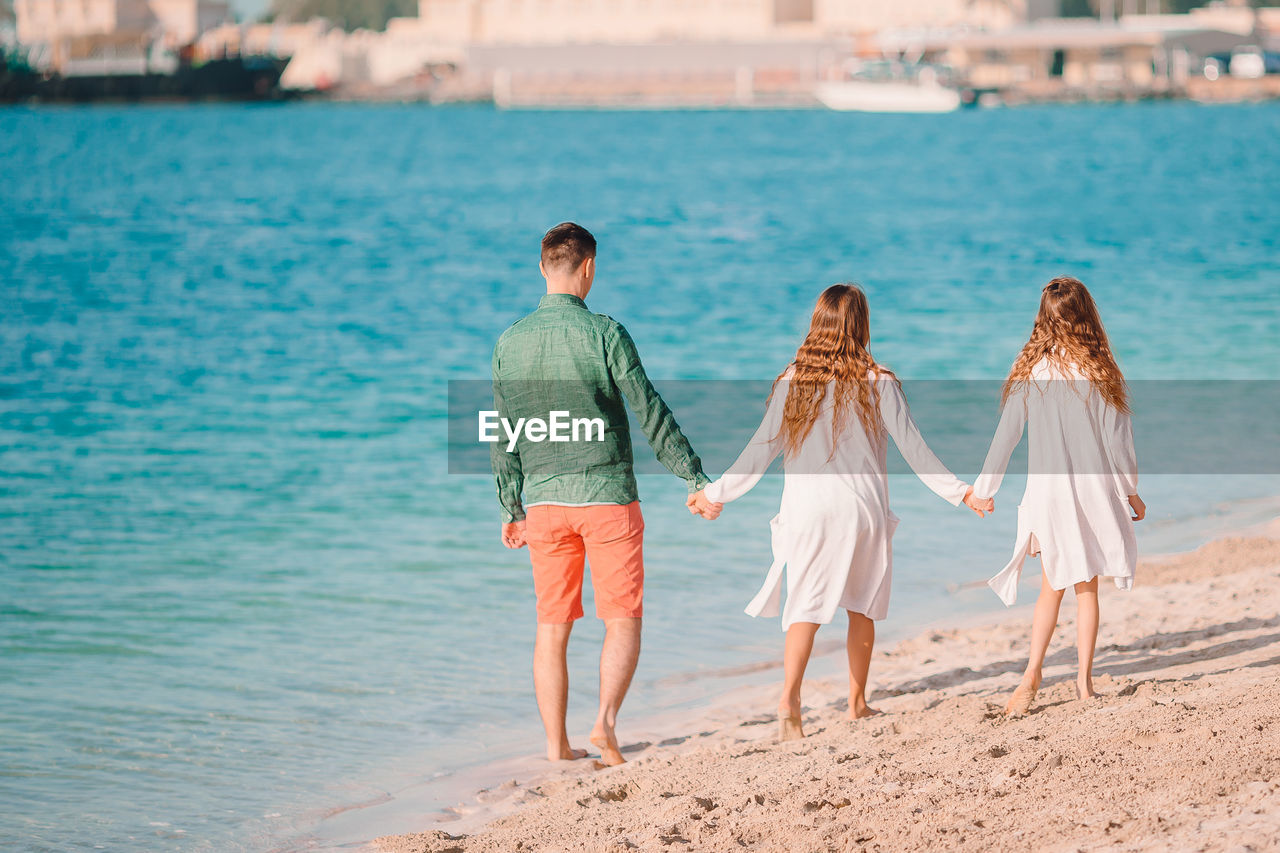 Rear view of women standing on beach