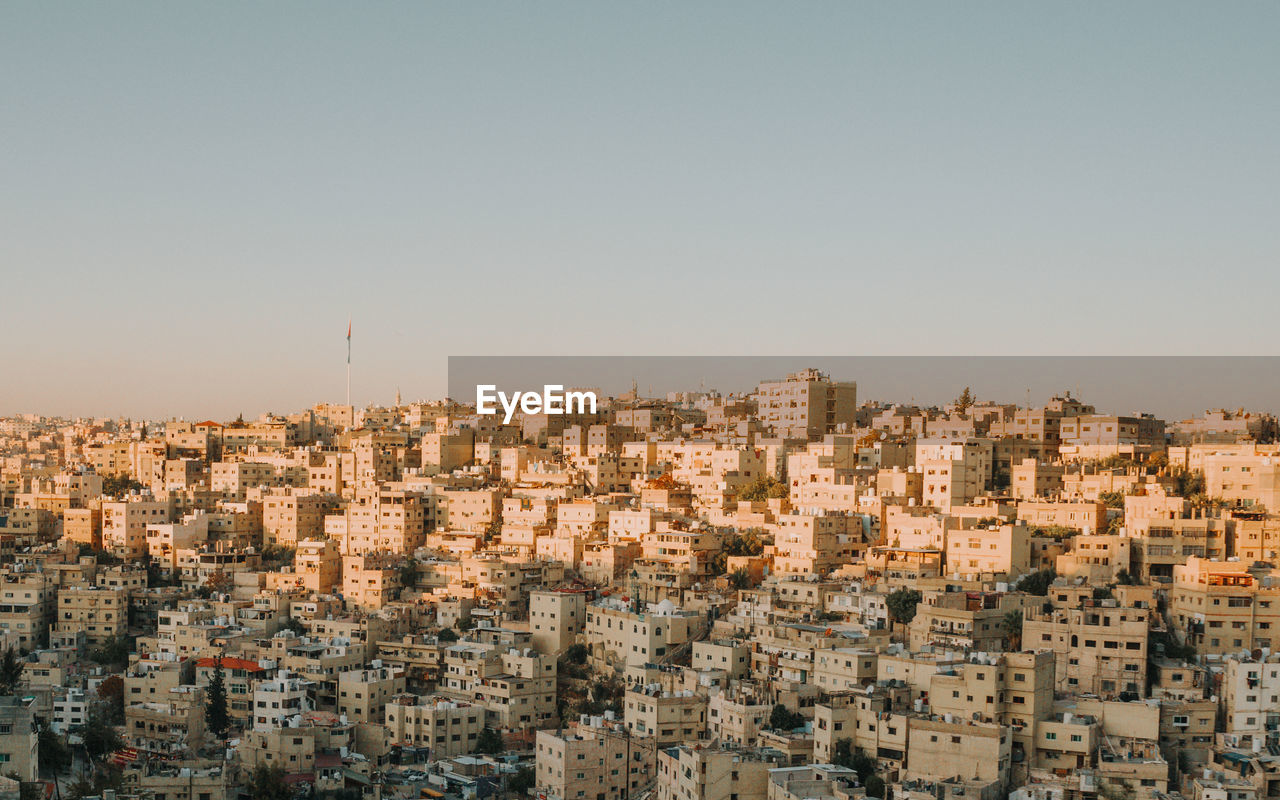 Aerial view of buildings in city against clear sky