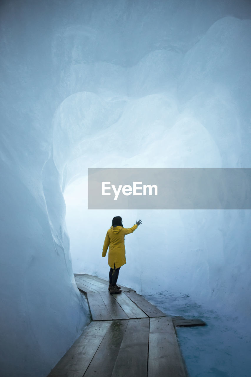 Rear view of woman standing in snow cave
