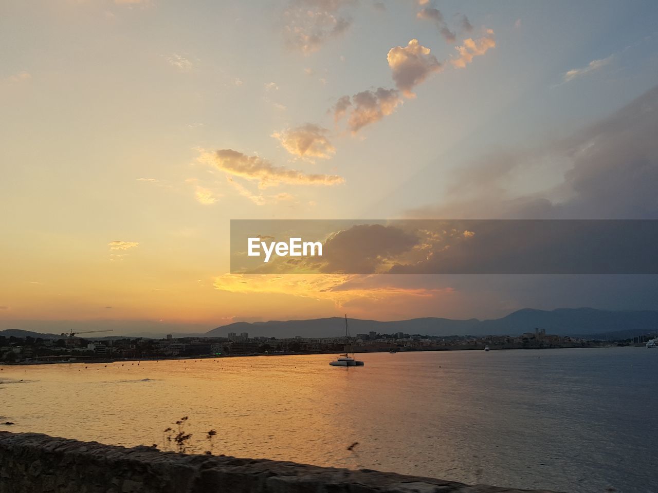 SCENIC VIEW OF BEACH AGAINST SKY AT SUNSET