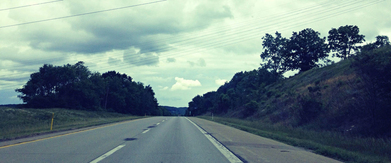 ROAD PASSING THROUGH LANDSCAPE AGAINST CLOUDY SKY