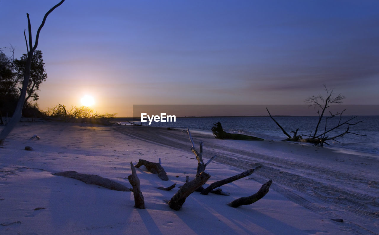 Idyllic view of beach against sky during sunset