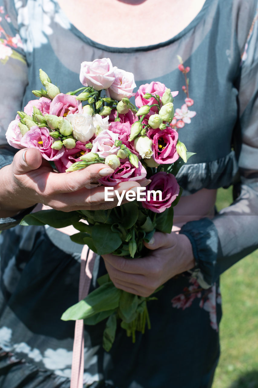 Middle-aged woman with a bouquet of pink eustomas a gift for mother's day,spring