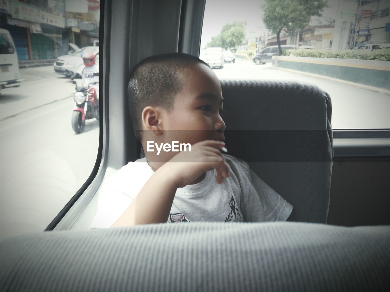 Boy looking away while sitting in car