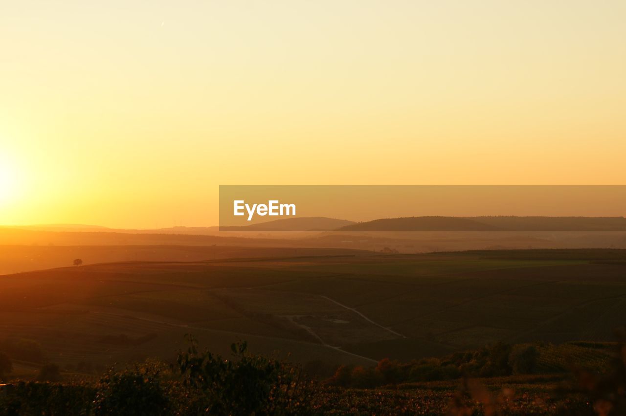 Scenic view of field against sky during sunset