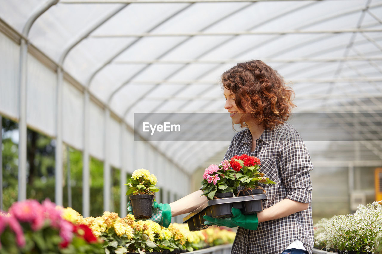 Woman with potted plants at nursery