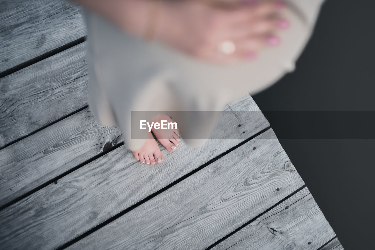 low section of person standing on wooden table