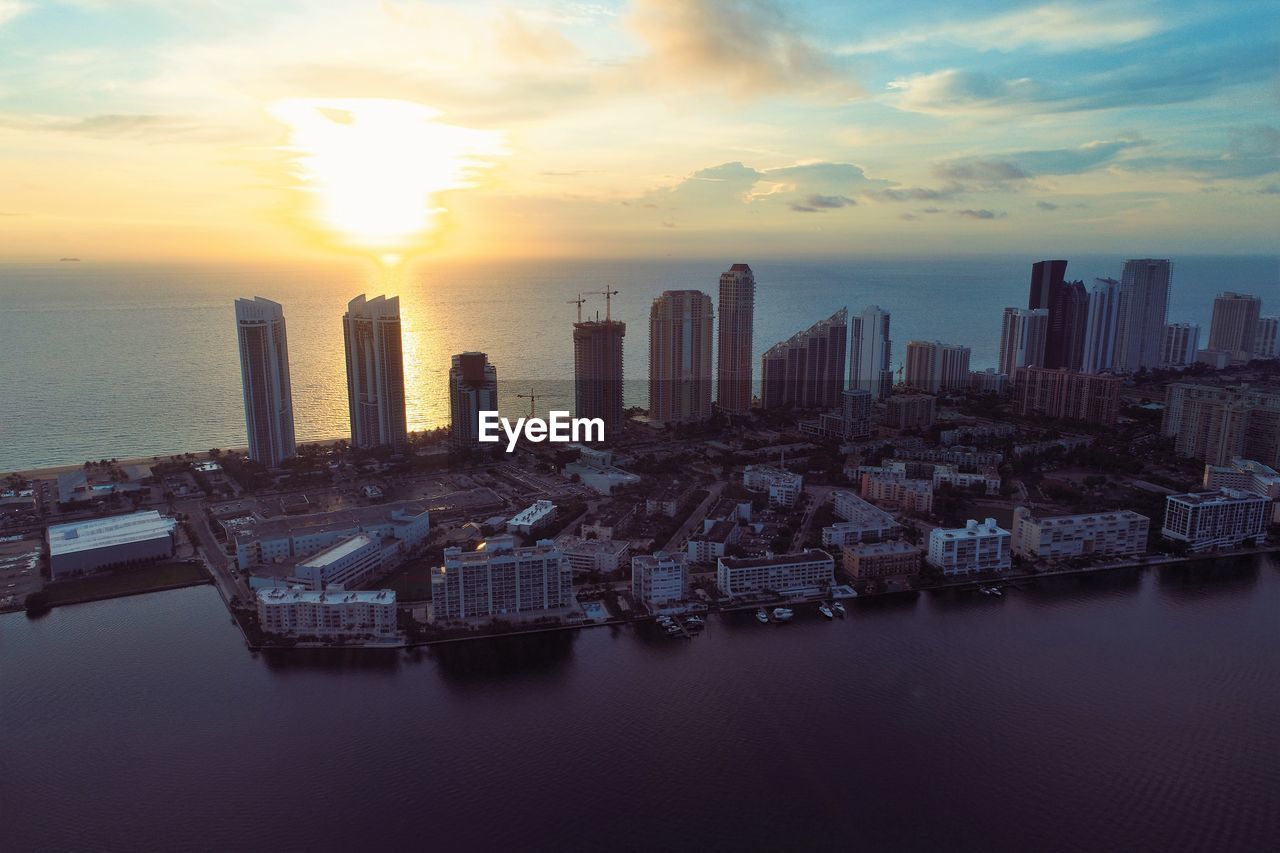 Aerial view of buildings in city during sunset