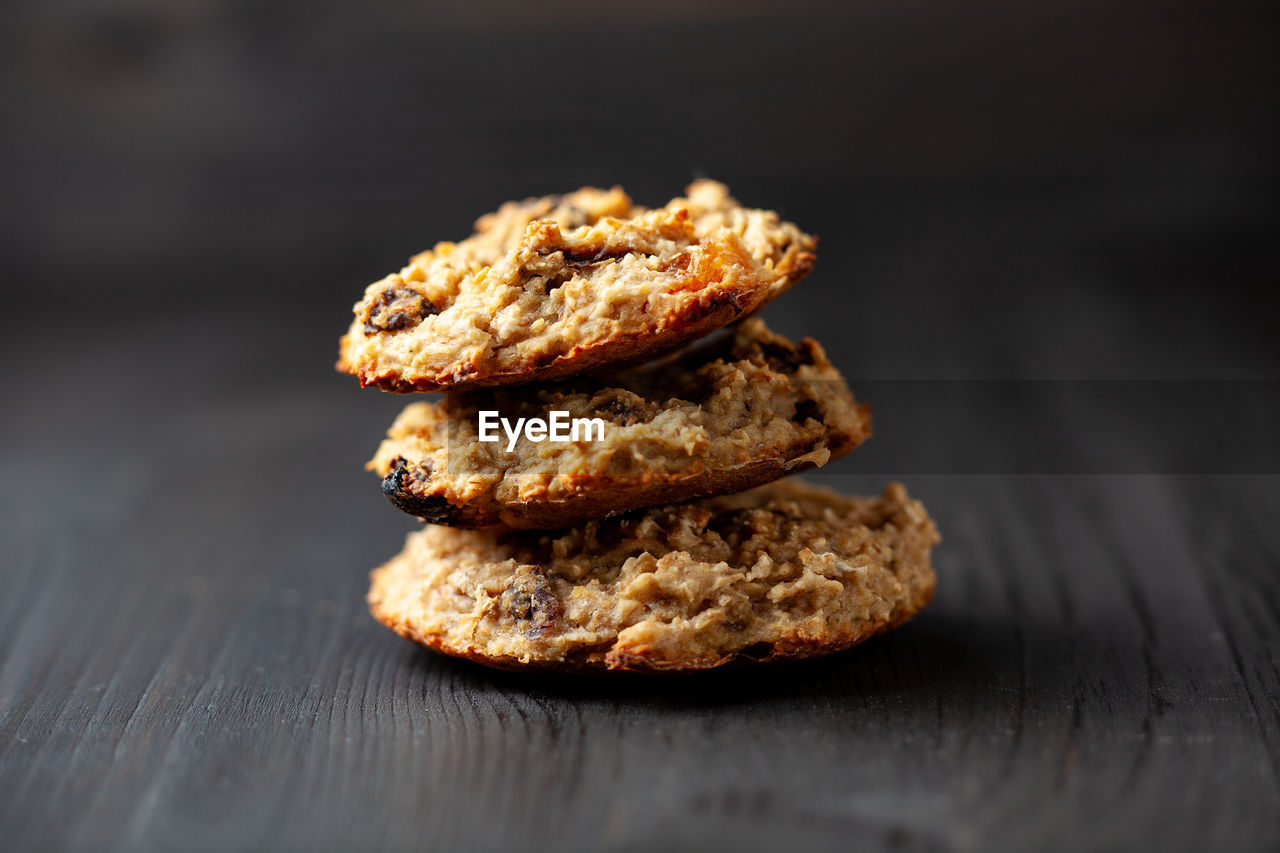 Homemade oatmeal cookies with raisins on a black wooden background