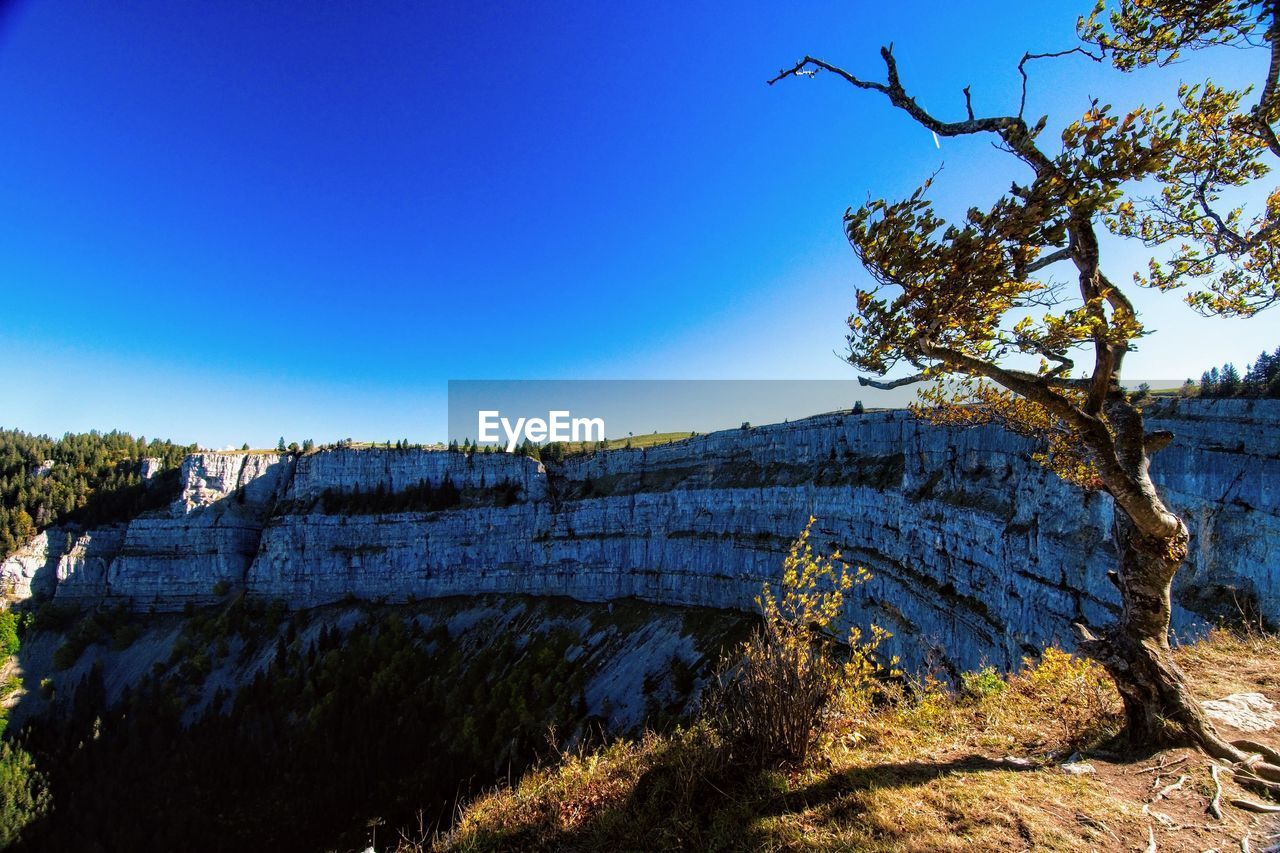 Scenic view of rocky mountains against clear blue sky