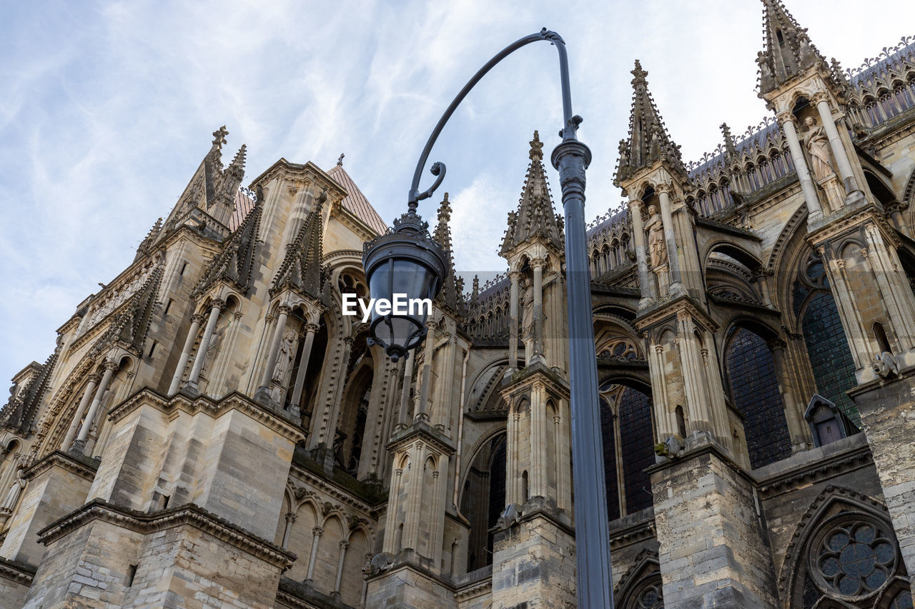 Low angle view at cathedral notre dame in reims, france with street lamp in foreground