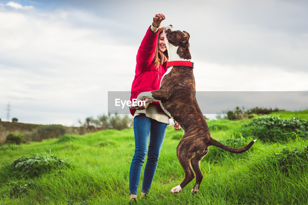 Woman with dog on field