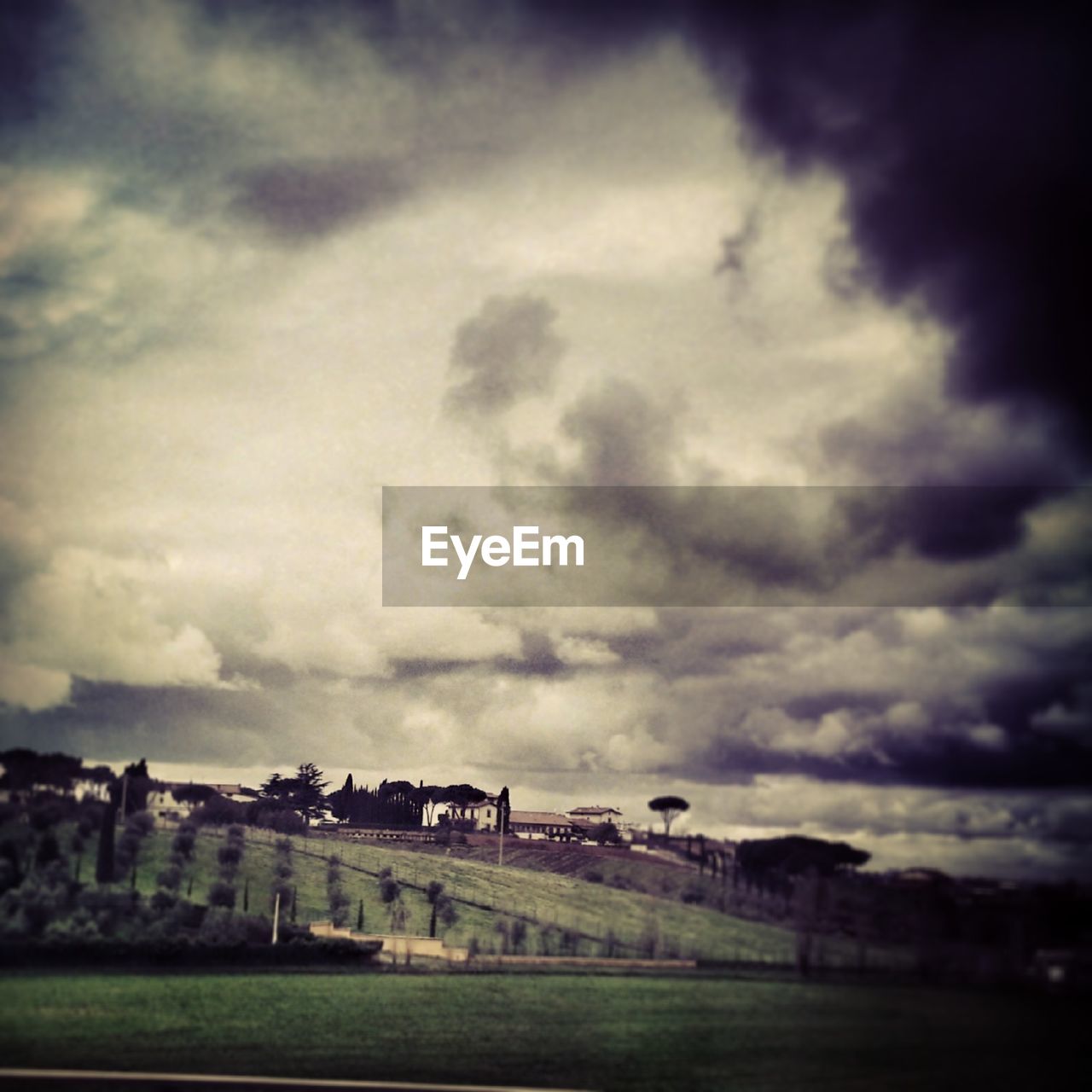 VIEW OF FIELD AGAINST CLOUDY SKY