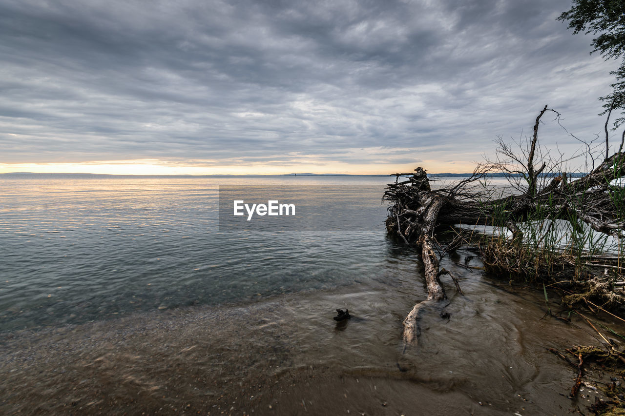 scenic view of sea against cloudy sky during sunset