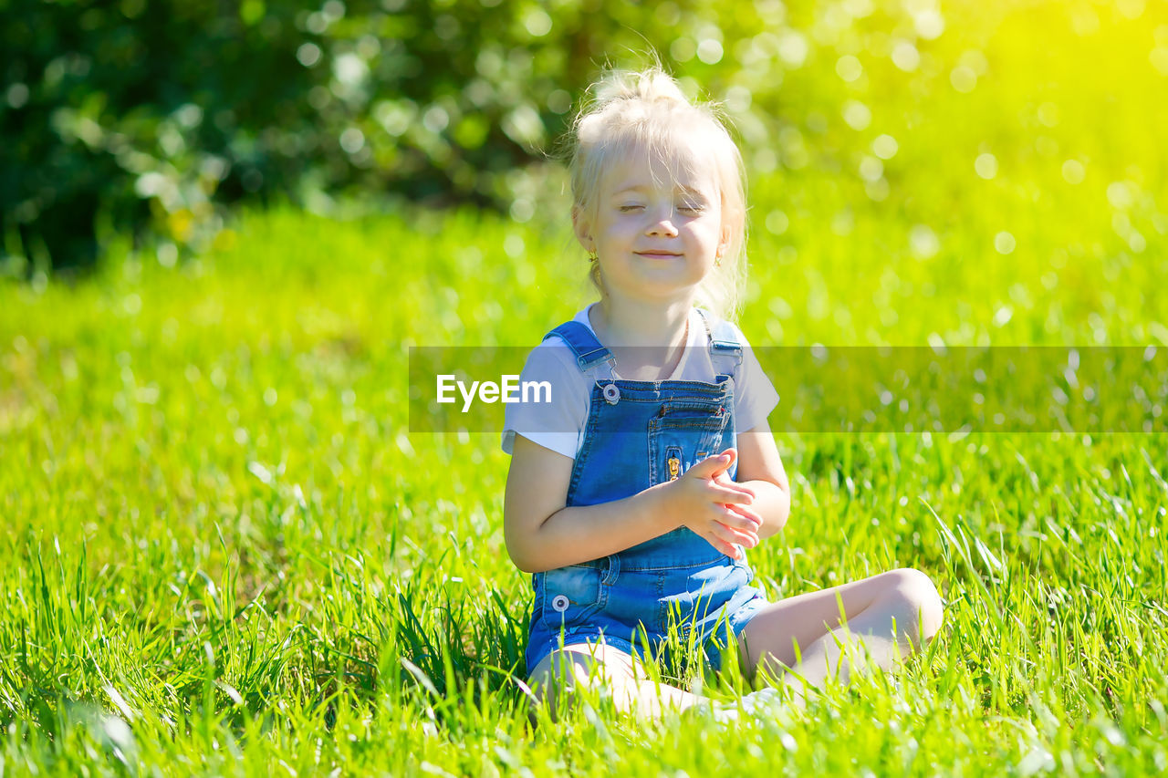 Girls running around the lawn with grass playing with splashes of water to water the plants.