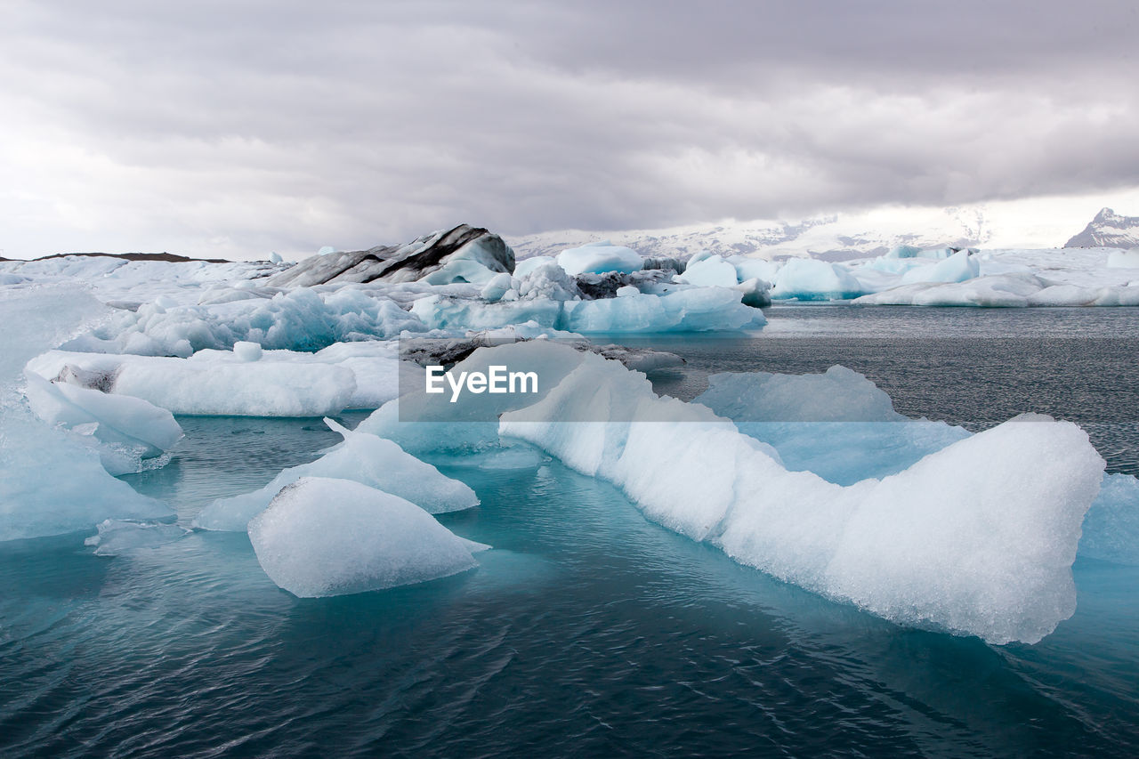 Icebergs floating in jökulsárlón, iceland, during a cloudy day