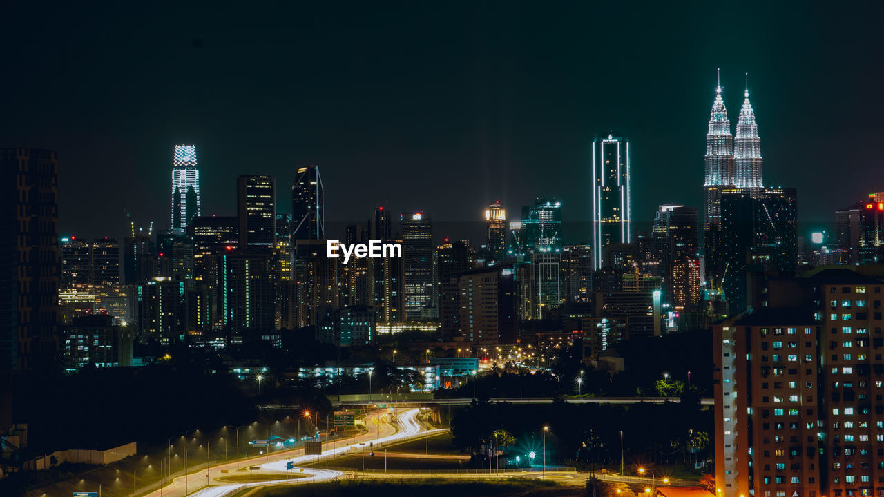 ILLUMINATED BUILDINGS IN CITY AT NIGHT