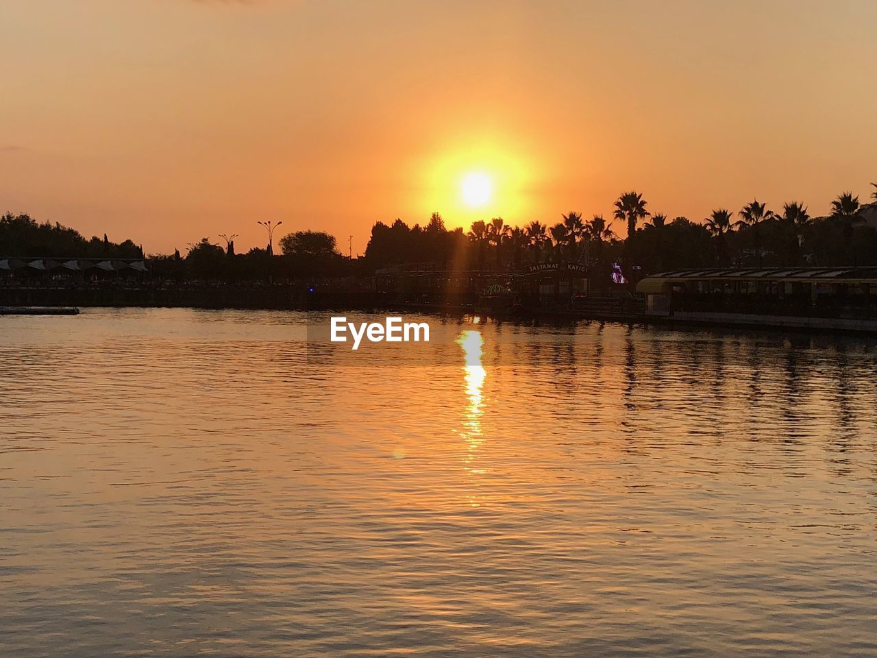 SCENIC VIEW OF LAKE AGAINST SKY AT SUNSET