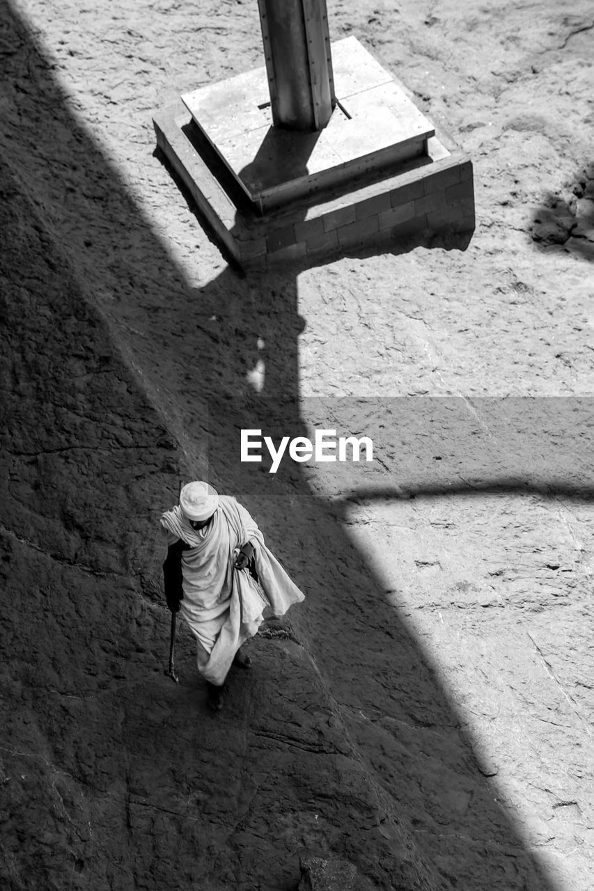 Aerial view of robed holy man walking amongst the rock-hewn churches of lalibela, ethiopia.