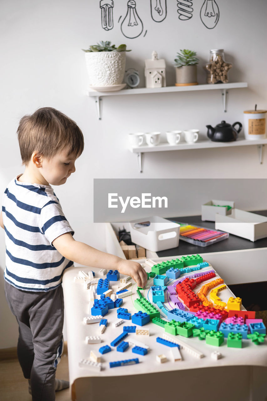 side view of boy playing with toy blocks