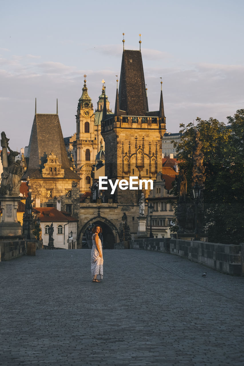 Woman walking through charles bridge, prague, czech republic